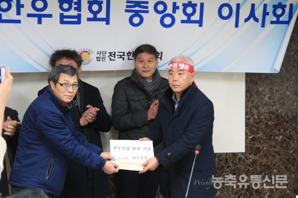 한우공감밴드 최군식 대표가 김홍길 전국한우협회장에게 성금을 전달하고 있다.