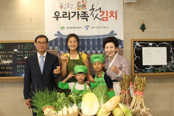 어린이 김치 클래스를 개최한 대아청과 이정수 대표(왼쪽)와 행사를 진행한 이하연 김치명인(오른쪽), 참여한 아이들과 부모(가운데)가 손 하트를 만들며 기념촬영을 하고 있다.